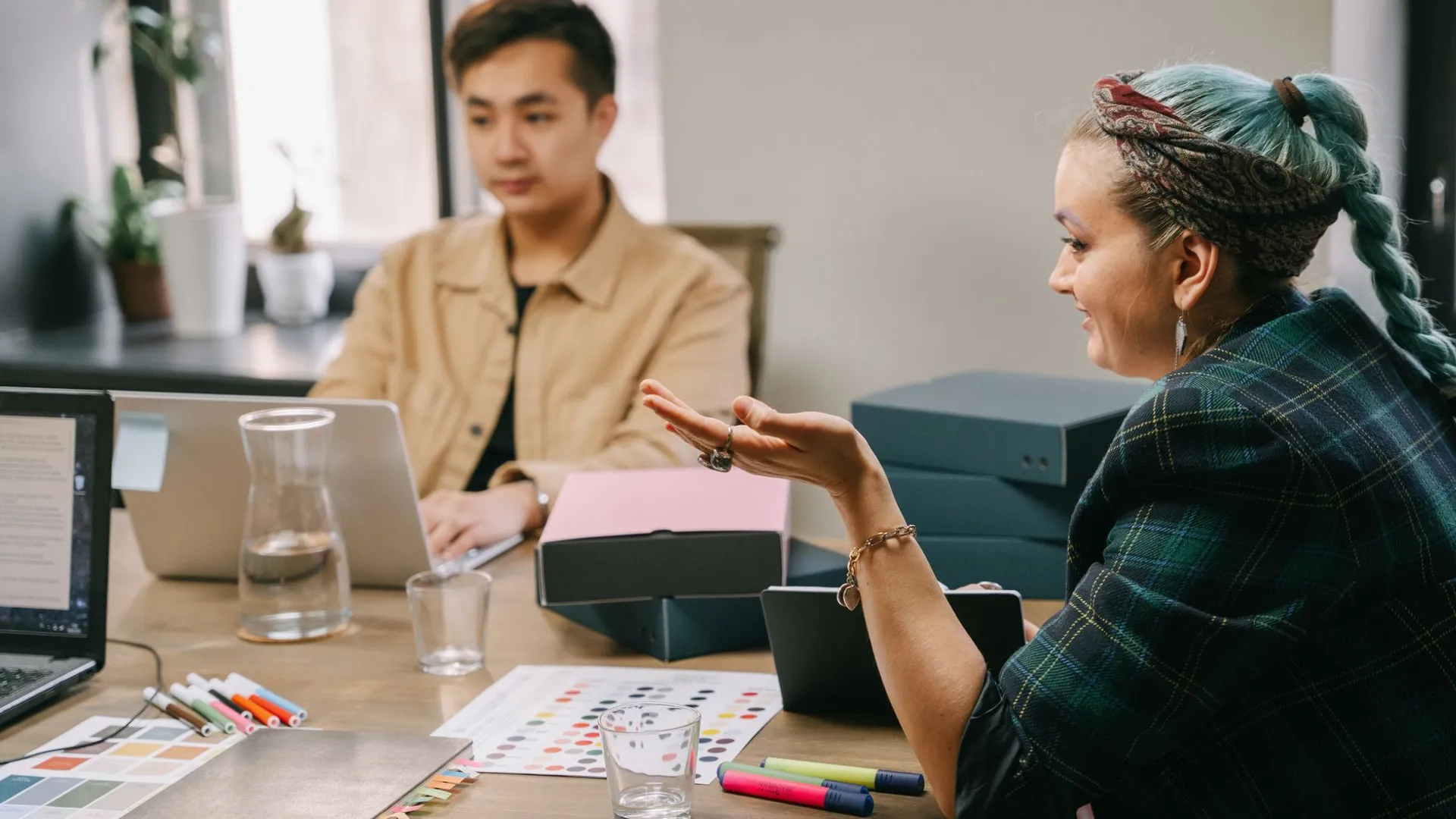 Two coworkers engaged in a productive strategy meeting at a modern office desk.