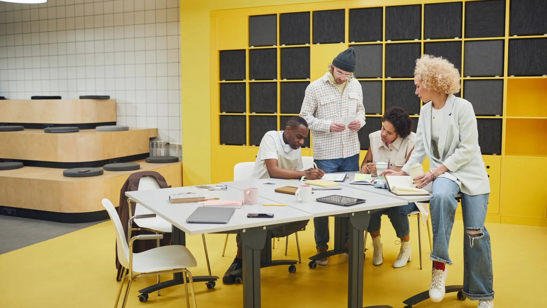 A diverse group of coworkers actively brainstorming and collaborating in a modern, colorful office setting.