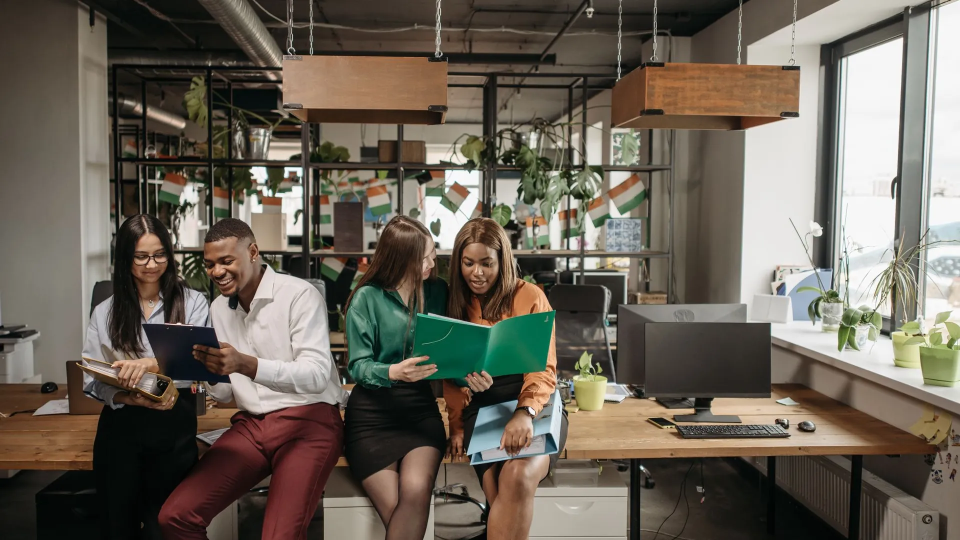 Group of colleagues sharing ideas in a vibrant office environment, promoting team collaboration and diversity.