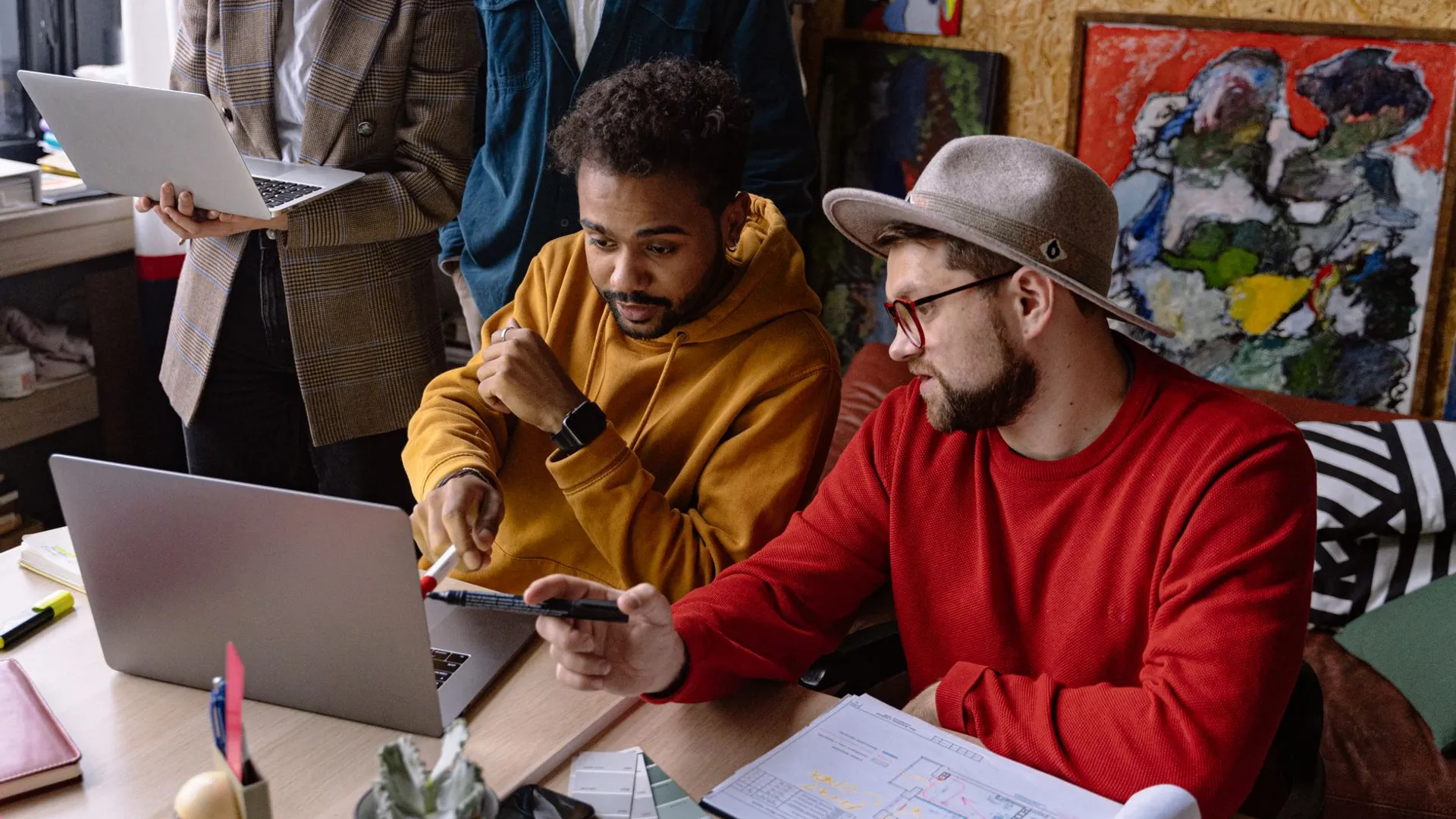 Diverse team in casual attire collaborating on a project in a creative workspace.